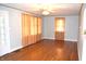 Bright living room with polished hardwood floors, vintage ceiling fan, and natural light streaming through patterned curtains at 1641 Winton Ave, Speedway, IN 46224