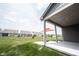 Covered back porch overlooking a large green yard with neighboring homes visible in the distance at 19800 Sutton Ter, Westfield, IN 46074