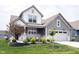Beautiful two-story home featuring a manicured lawn, covered porch, and attached two-car garage at 19800 Sutton Ter, Westfield, IN 46074