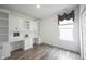 Bright home office with custom white cabinets and shelving with a window letting in natural light at 19800 Sutton Ter, Westfield, IN 46074