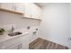 Well-lit laundry room features white cabinets, utility sink, and convenient washer/dryer connections at 19800 Sutton Ter, Westfield, IN 46074