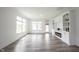 Inviting living room featuring hardwood floors, large windows, and a cozy fireplace at 19800 Sutton Ter, Westfield, IN 46074