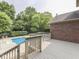 Back deck with a wooden railing, offering views of the pool and lush landscaping, ideal for relaxation at 20 Forrests Edge Ct, Indianapolis, IN 46227