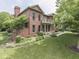 Red brick home with manicured landscaping, a balcony, and a side-entry garage in a lush setting at 20 Forrests Edge Ct, Indianapolis, IN 46227