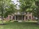 Beautiful brick home featuring a well-maintained lawn, mature trees, and a covered front porch at 20 Forrests Edge Ct, Indianapolis, IN 46227