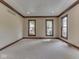 Neutral living room with three windows, carpet, and detailed ceiling at 20 Forrests Edge Ct, Indianapolis, IN 46227