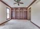 Carpeted room with large built-in wooden bookshelves and a window for natural light at 20 Forrests Edge Ct, Indianapolis, IN 46227