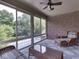 Cozy sunroom with brick accent wall, wicker furniture, and views of the backyard pool at 20 Forrests Edge Ct, Indianapolis, IN 46227