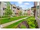 Exterior showcasing townhomes, green grass, landscaped areas, and a sidewalk through the community at 2125 Coretta Way, Indianapolis, IN 46202