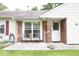 Close-up of front porch with brick accents, seating, and welcome sign, offering a cozy entrance at 254 Bittersweet Dr, Whiteland, IN 46184