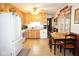 Cozy kitchen features tile floors, wooden cabinets, white appliances and an inviting dining area at 254 Bittersweet Dr, Whiteland, IN 46184