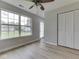 Bright bedroom featuring light wood floors, a ceiling fan, and a large window overlooking the backyard at 2756 Branigin Creek Blvd, Franklin, IN 46131