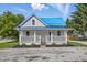 Charming home with a blue metal roof and welcoming front porch, set against a bright blue sky at 300 N Church St, Arcadia, IN 46030