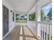 Inviting front porch with wood flooring, classic white columns, and serene neighborhood views at 300 N Church St, Arcadia, IN 46030