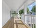Open-air front porch features wood flooring, classic white columns, and neighborhood views at 300 N Church St, Arcadia, IN 46030
