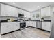 Well-lit kitchen showcasing stainless steel appliances, white cabinetry, and dark countertops at 300 N Church St, Arcadia, IN 46030