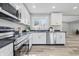 Modern kitchen with stainless appliances, white cabinets, and dark countertops; open layout to dining area at 300 N Church St, Arcadia, IN 46030