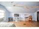 Attic bedroom featuring hardwood floors, desk, TV, and unique wooden beam in ceiling at 3004 Sheridan St, Anderson, IN 46016