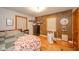 Comfortable bedroom with hardwood floors, two windows, and a decorative accent wall at 3004 Sheridan St, Anderson, IN 46016