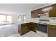 Kitchen featuring wood cabinets, white countertops, and an adjacent living area with natural light at 310 W Jackson St, Alexandria, IN 46001