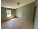 Minimalist bedroom with green walls, trim, and one window offering natural lighting and backyard views at 3587 Lower Patton Park Rd, Martinsville, IN 46151