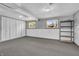 Finished basement featuring carpeted flooring, shelving, two windows and painted walls at 3624 Woodcliff Dr, Indianapolis, IN 46203
