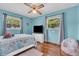 Modern bedroom with hardwood floors, turquoise walls, and natural light from multiple windows at 3624 Woodcliff Dr, Indianapolis, IN 46203