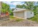 A detached single-car garage with gravel driveway and an adjacent deck at 3624 Woodcliff Dr, Indianapolis, IN 46203