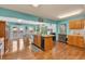 Spacious kitchen featuring bright turquoise walls, hardwood floors, and an island with sink at 3624 Woodcliff Dr, Indianapolis, IN 46203