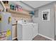 Well-lit laundry room with a washer, dryer, utility sink, shelving and a newer water heater at 3624 Woodcliff Dr, Indianapolis, IN 46203