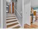 Staircase leading to the second floor, featuring hardwood steps, white risers, and neutral wall paint at 3624 Woodcliff Dr, Indianapolis, IN 46203