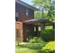 Brick home featuring a covered porch, side door, and lush greenery, blending classic architecture with natural beauty at 3702 N Delaware St, Indianapolis, IN 46205