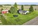 Aerial view shows a sprawling yard with a trampoline, red barn, and a beautifully maintained lawn and property at 3840 W 38Th St, Anderson, IN 46011