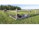 A small group of goats stand behind a rustic fence in the middle of a large green pasture on a sunny day at 3840 W 38Th St, Anderson, IN 46011