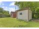 View of the backyard with two sheds on a green lawn, one red and one beige at 3898 S Randolph St, Indianapolis, IN 46227