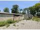 Rustic exterior view of building with weathered cinder blocks and gravel landscaping, offering a unique renovation opportunity at 4566 Melbourne Rd, Indianapolis, IN 46228