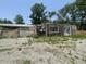 View of the back of the building on a lot with a gravel surface and some grass at 4566 Melbourne Rd, Indianapolis, IN 46228