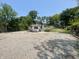 View of the side of the building in the center of a lot with a gravel surface and some grass at 4566 Melbourne Rd, Indianapolis, IN 46228