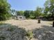 A graveled open space with a small building, piles of rocks, trees, and overgrown vegetation at 4566 Melbourne Rd, Indianapolis, IN 46228