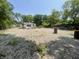 A graveled open space with a small building, piles of rocks, trees, and overgrown vegetation at 4566 Melbourne Rd, Indianapolis, IN 46228