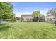 Lush backyard with mature trees, a fire pit, and a playground at 4642 Big Run Ct, Indianapolis, IN 46239