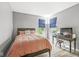Cozy bedroom with gray walls, wood floors, a full-sized bed, and a workspace area at 4642 Big Run Ct, Indianapolis, IN 46239