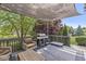 Relaxing covered deck with outdoor seating and a grill overlooking a manicured backyard at 4642 Big Run Ct, Indianapolis, IN 46239