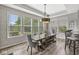 Bright dining room with large windows, modern wallpaper, and rustic wood table at 4642 Big Run Ct, Indianapolis, IN 46239
