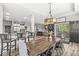 Open-concept dining room featuring a rustic wood table, modern pendant lighting, and access to outdoor patio at 4642 Big Run Ct, Indianapolis, IN 46239