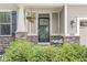 Charming front porch with decorative hanging plants and manicured bushes at 4642 Big Run Ct, Indianapolis, IN 46239