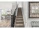 Stairway leading to the upper level, showcasing modern design and neutral tones, with a glimpse of the kitchen at 4642 Big Run Ct, Indianapolis, IN 46239
