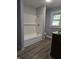 Bathroom featuring a bathtub with white subway tile, wood-look flooring, and a large window at 509 Shelby St, Shelbyville, IN 46176