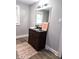 Bathroom featuring a large mirror, vanity with black granite top, LVP flooring and natural light at 509 Shelby St, Shelbyville, IN 46176