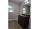 Bathroom featuring a single vanity with a granite countertop, wood-look flooring, and a large window at 509 Shelby St, Shelbyville, IN 46176